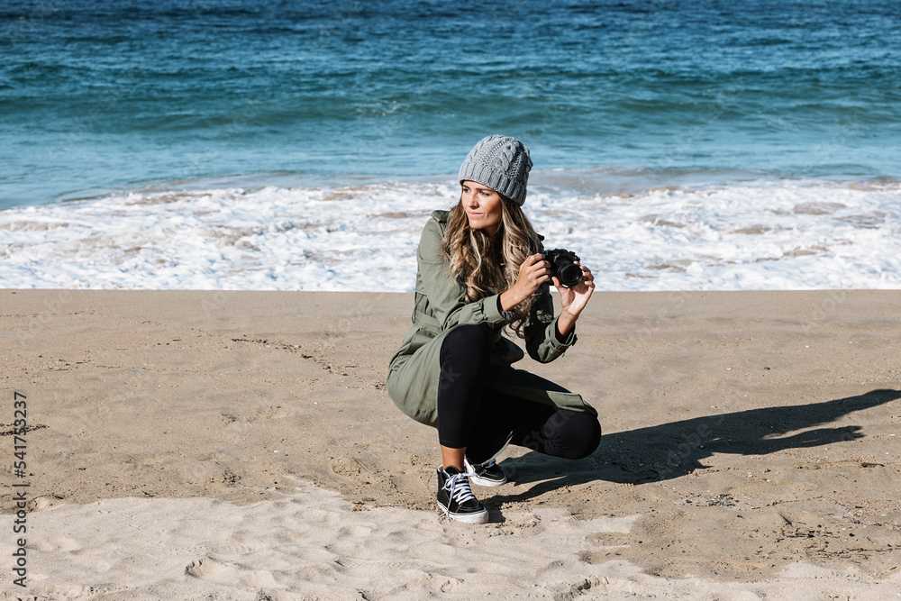 Young woman photographing seascape on beach Young woman photographing seascape on beach