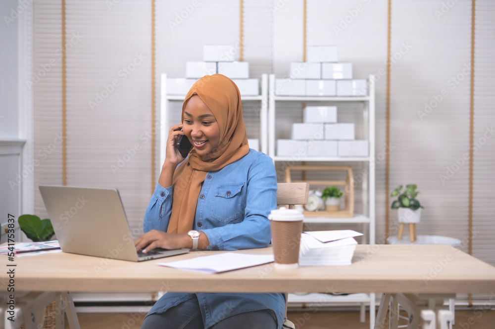 Smiling African female business owner using digital tablet and talking on the phone .Online shopping and start up concept. Smiling African female business owner using digital tablet and talking on the phone .Online shopping and start up concept.
