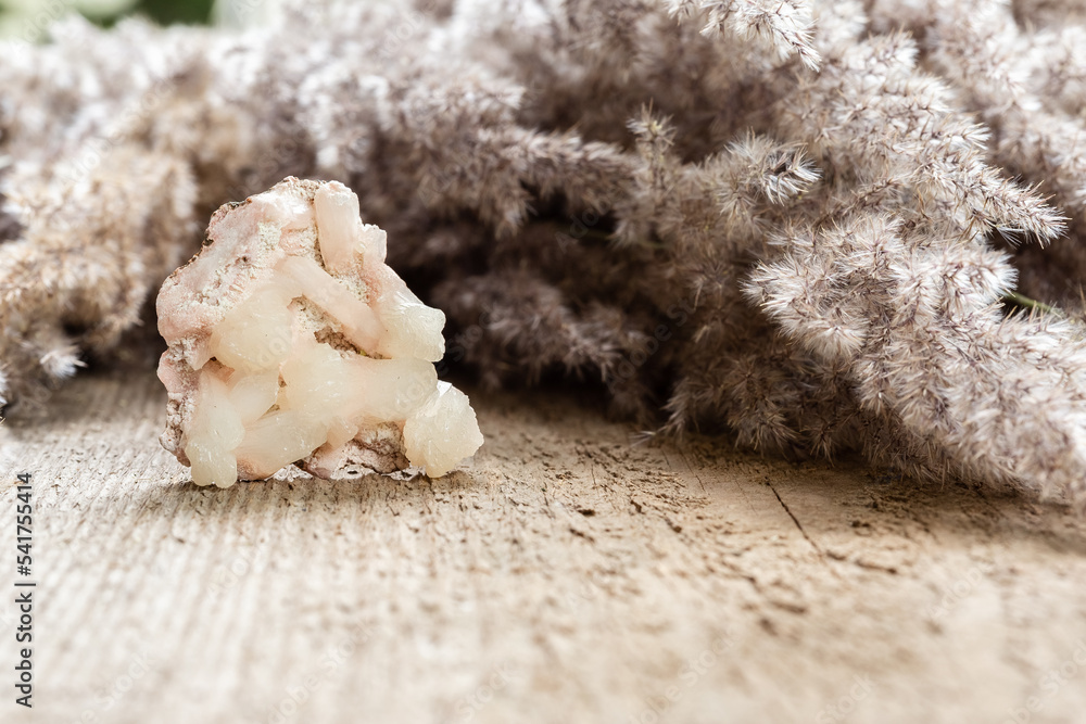 Raw Stilbite crystal sample on wood with copyspace Raw Stilbite crystal sample on wood with copyspace
