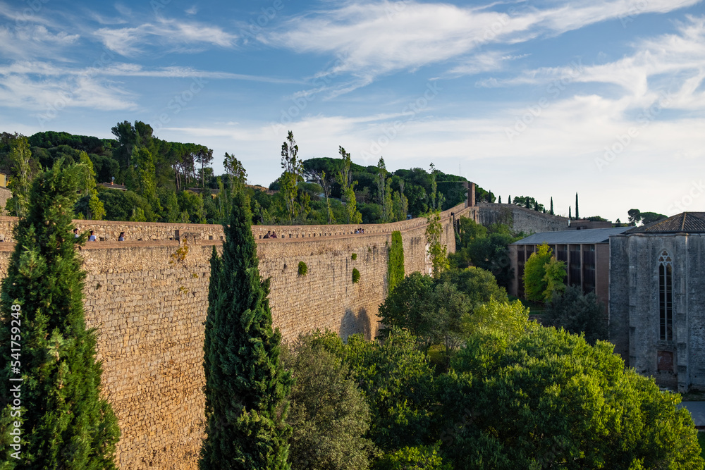 Girona, Spain, 22 October 2022: Girona old City Walls Walkway on sunny summer day, known as Passeig de la Muralla. Old roman walls