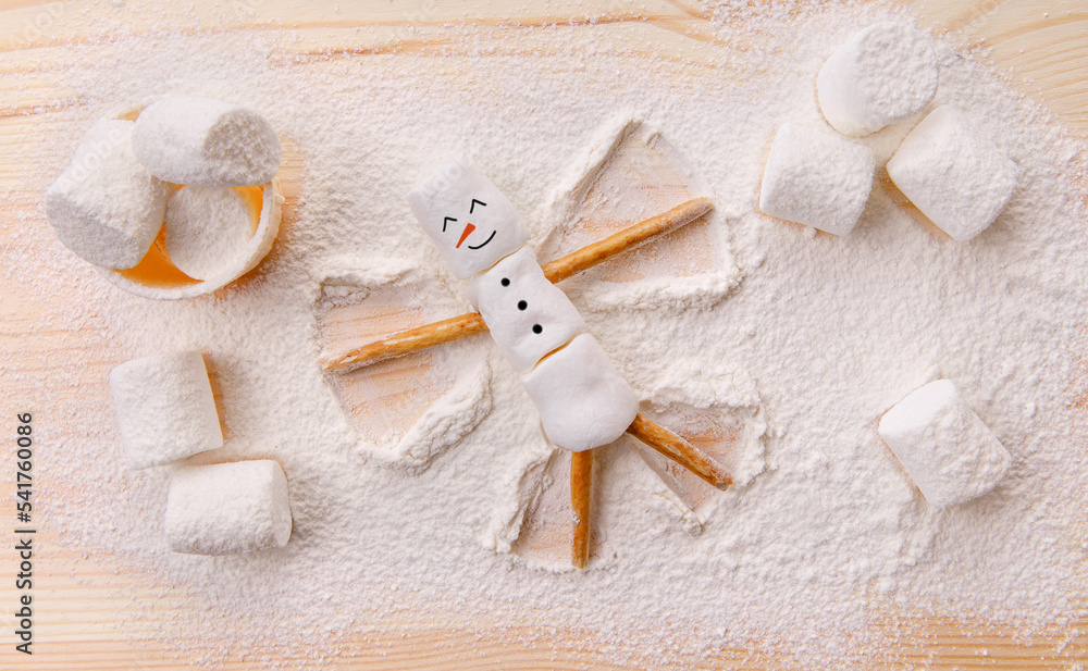 Christmas happy marshmallow man making an angel on the snow Christmas happy marshmallow man making an angel on the snow