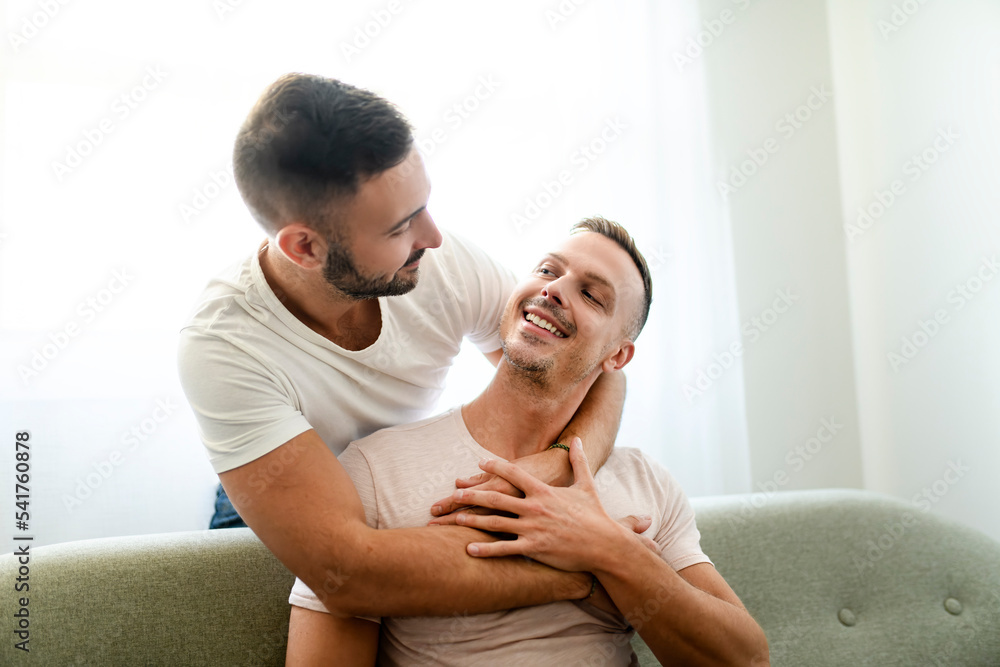 Young two man couple at modern home happy smiling have romantic time in living room at house. Young two man couple at modern home happy smiling have romantic time in living room at house.