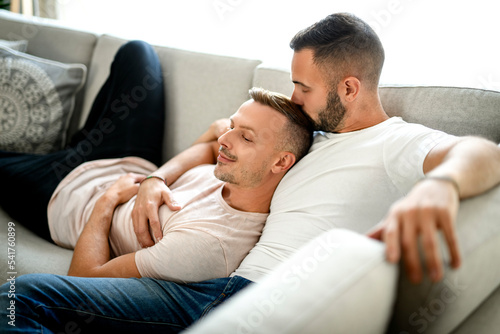 Same sex male couple smiling for the camera at home.