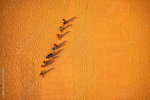 Aerial view of farmers working in a field drying rice on a rice field in Dhamrai, Dhaka, Bangladesh. photo