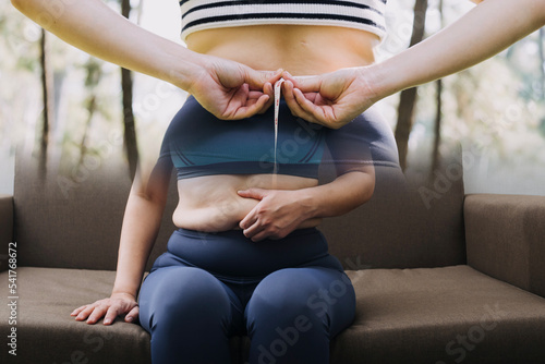 Obraz na plátne Beautiful fat woman with tape measure She uses her hand to squeeze the excess fat that is isolated on a white background