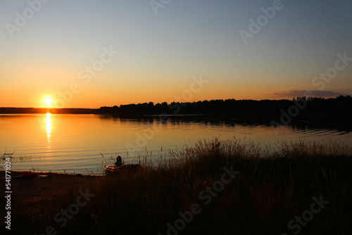 Inflatable rubber boat with a motor near the shore  on the lake in the evening