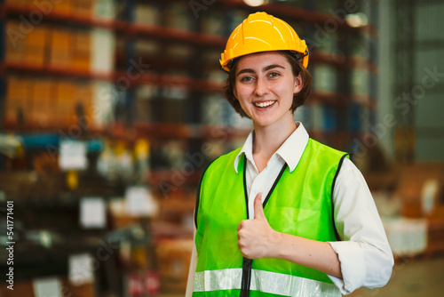 фотографія Portrait of young woman in safety jacket and wearing hardhat raised thump up and smiling to the camera