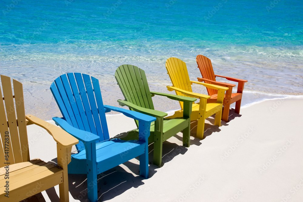 Colored beach  chairs on white sand 