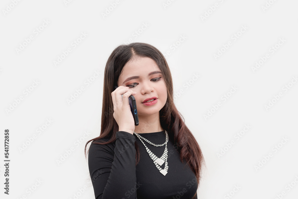 A studio photo of an Asian lady talking on the phone with her friend. Isolated on a white background. Studio shot isolated on a white background. A studio photo of an Asian lady talking on the phone with her friend. Isolated on a white background. Studio shot isolated on a white background.
