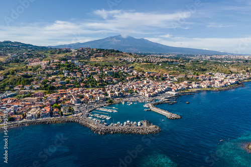 Aerial view of Aci Trezza, a small town along the coast with Etna Volcano in background, Sicily, Italy. photo