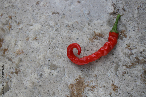 red hot hot chili pepper lies on a stone marble cutting kitchen board. for banners leaflets labels signage recipes
