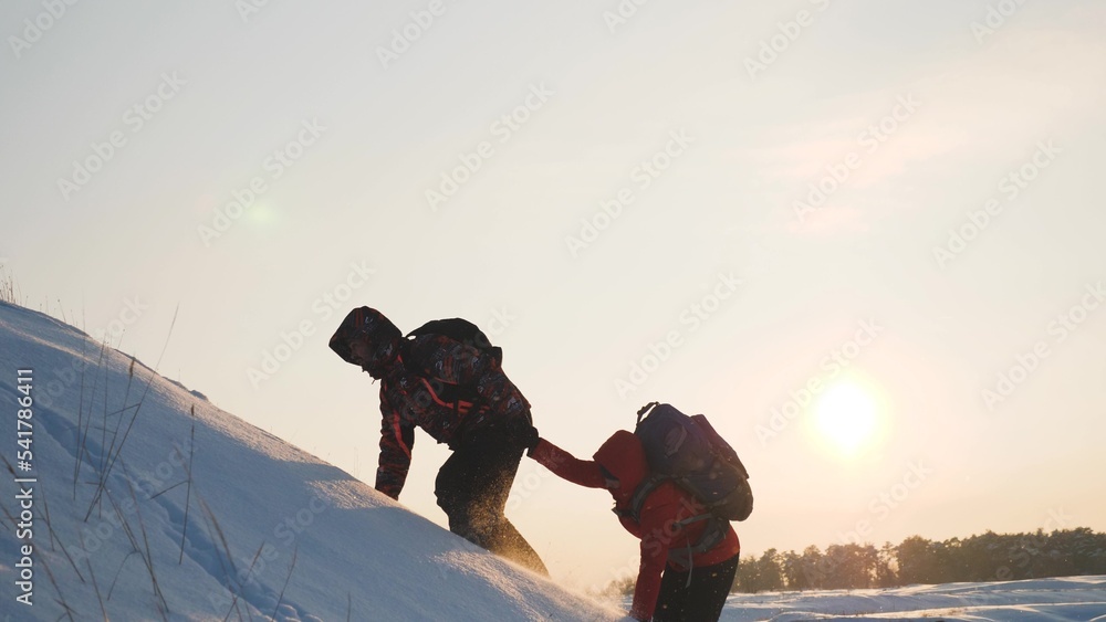 travelers climb snowy mountain sunset winter. hiking concept winter