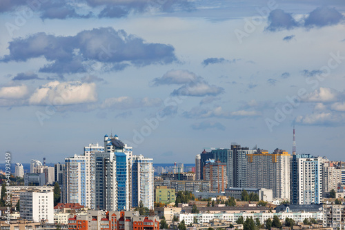 The modern architecture of new buildings rises above the roofs of old buildings in the urban landscape.