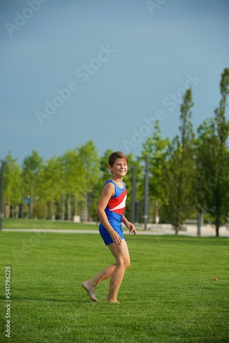 Boy gymnast school age in a suit shows the elements of the sport. Boy gymnast school age in a suit shows the elements of the sport.