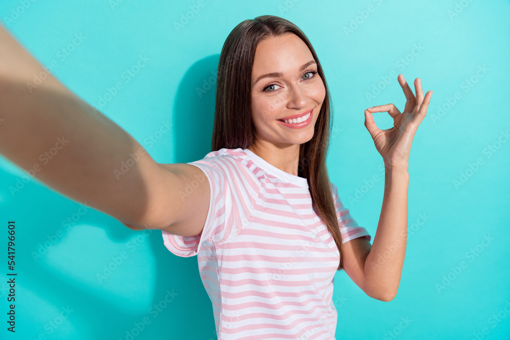 Portrait of positive funny woman with long hairdo dressed striped t-shirt shrug shoulders excuses isolated on teal color background Portrait of positive funny woman with long hairdo dressed striped t-shirt shrug shoulders excuses isolated on teal color background