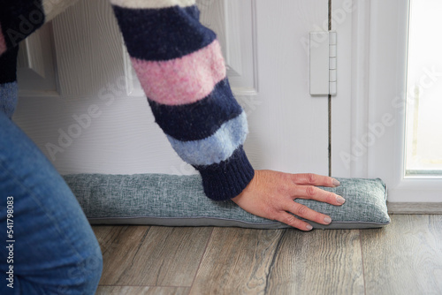Photos Woman Saving Enegy Insulating Home Putting Draught Excluder Tape On Window