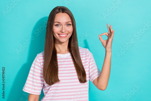 Photo of nice cute positive girl with straight hairdo dressed striped t-shirt showing okey approve isolated on teal color background