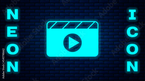 Glowing neon Movie clapper icon isolated on brick wall background. Film clapper board. Clapperboard sign. Cinema production or media industry. Vector