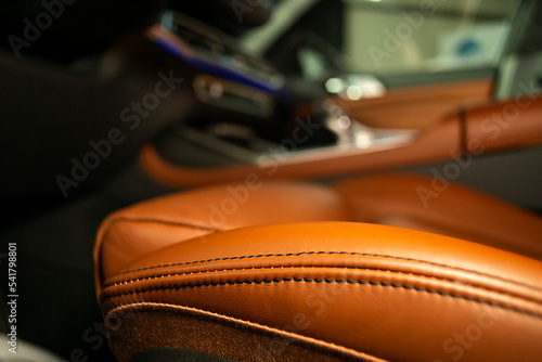 Soft focus close up of an orange leather driver's seat © Dorin