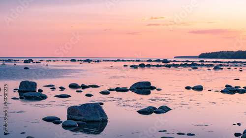 Beautiful colorful sunset landscape on the rocky shore of a peaceful sea. High quality photo