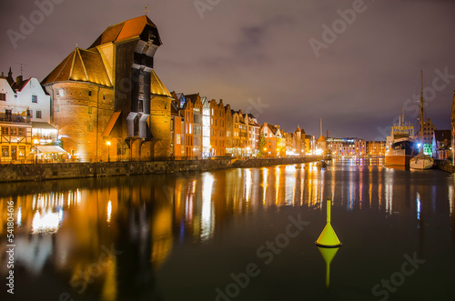 Panorama of the Gdansk waterfront at night with reflection and city lights