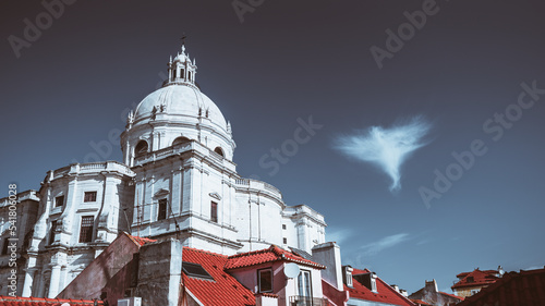 View of The Church of Santa Engracia or another name National Pantheon bright cold day  with a deep blue sky and a single cloud in the form of an angel next to the dome and red roofs of houses