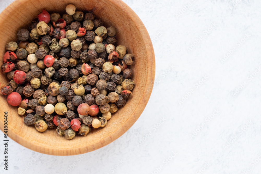 Mix of pepper peas in a wooden bowl and red hot chili peppers on white table background. Top view, flat lay, copy space Mix of pepper peas in a wooden bowl and red hot chili peppers on white table background. Top view, flat lay, copy space