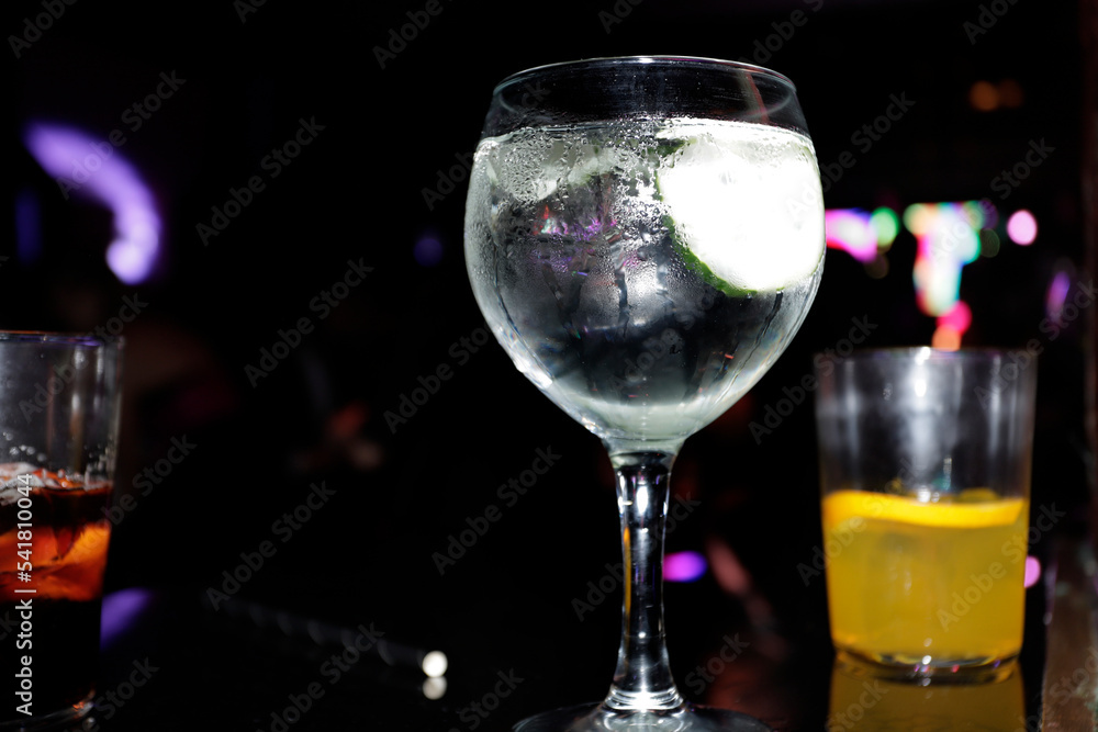 Fototapeta premium glass and glasses in discotheque on table with lights