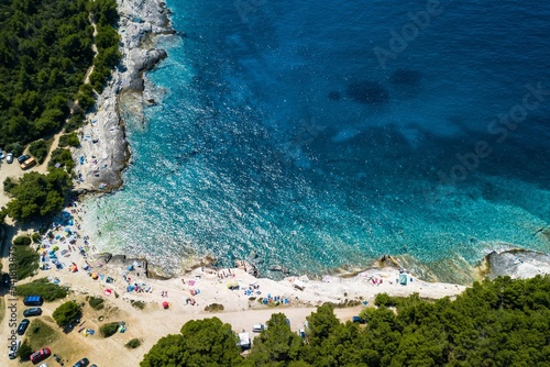 Aerial shot of a beautiful beach surrounded by greenery in Premantura, Croatia photo