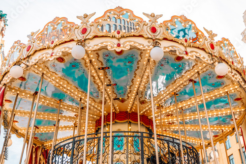 Colorful carousel with wooden horses in Barcelona, ​​Spain. Vintage carrousel. Dreamy magical blurred shape of a carousel