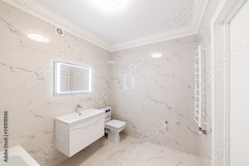 bathroom interior design with light tiles and lighting
