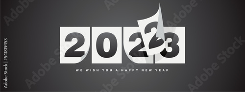 Happy New Year 2023 greeting card design template on black background. New Year 2023 start concept. Calendar pages turn in the wind and the new year begins