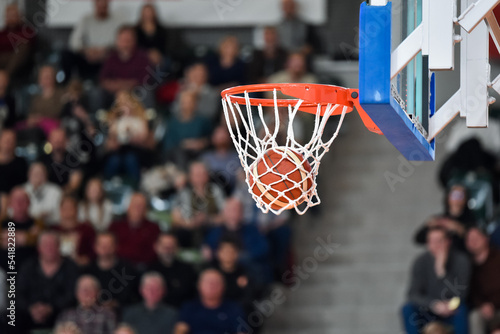 The ball falling into the basket during a basketball game
