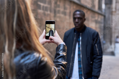 Girlfriend making photograph of her boyfriend in the street.