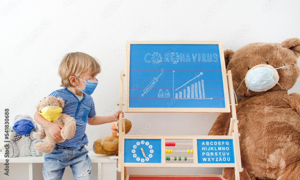 Cute child boy in home quarantine playing with toys wearing medical