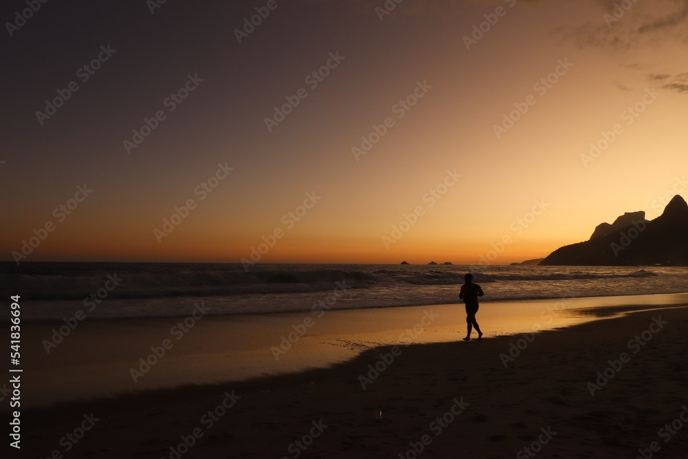 Rio de Janeiro, RJ, Brazil, 2022 - People walking in silhouette at Ipanema Beach at sunset