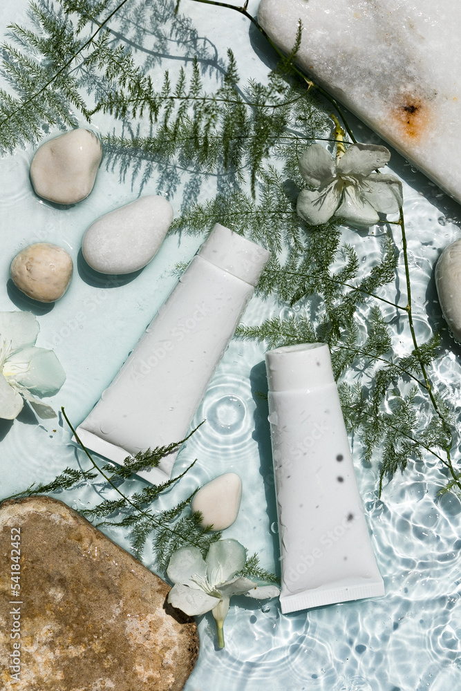 White cosmetic products in tubes , Mock up packages on water surface. Natural moisturizing water balance cosmetics product. White cosmetic products in tubes , Mock up packages on water surface. Natural moisturizing water balance cosmetics product.