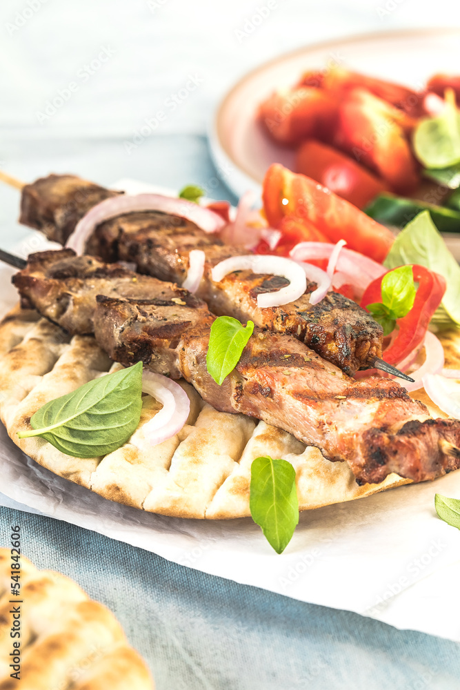 Pork souvlaki, kebabs on skewers with salad and fresh home made tzatziki Pork souvlaki, kebabs on skewers with salad and fresh home made tzatziki
