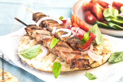 Pork souvlaki, kebabs on skewers with salad and fresh home made tzatziki