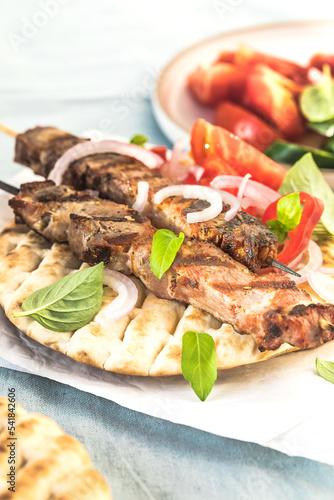 Pork souvlaki, kebabs on skewers with salad and fresh home made tzatziki