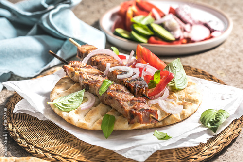 Pork souvlaki, kebabs on skewers with  salad and fresh home made tzatziki