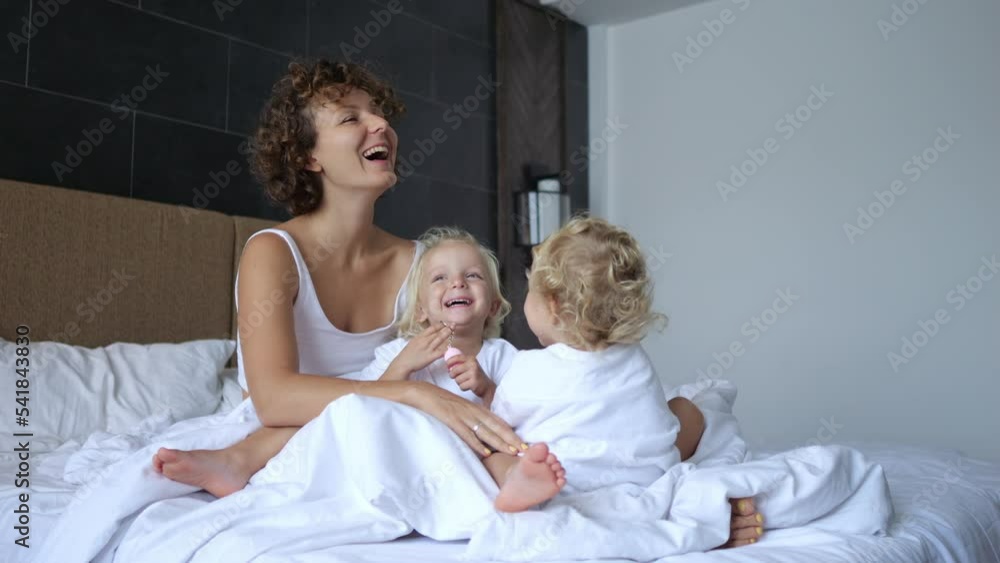 Carefree childhood concept. Run to my mother as soon as I woke up and opened my eyes and sit with her in bed. Laugh, have fun and hug. Feel unconditional parental love. Carefree childhood concept. Run to my mother as soon as I woke up and opened my eyes and sit with her in bed. Laugh, have fun and hug. Feel unconditional parental love.