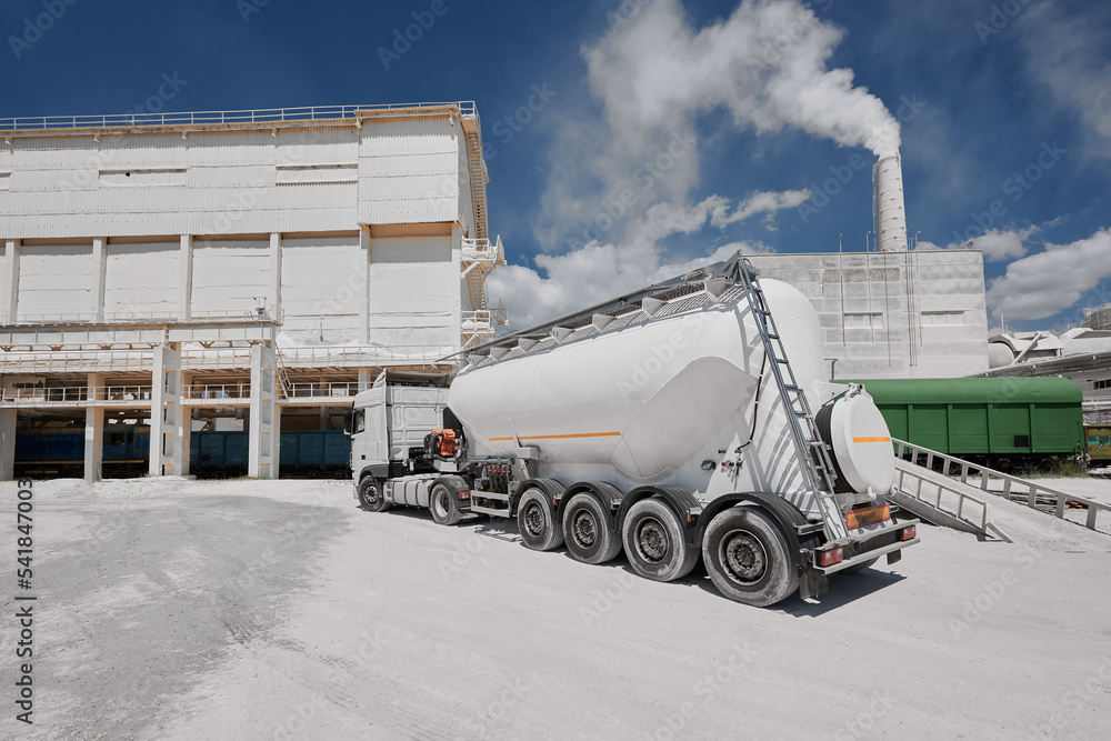 Modern cement trailer near warehouse of production plant - obrazy, fototapety, plakaty 