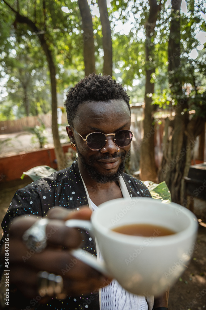 A man holding up a cup of tea A man holding up a cup of tea