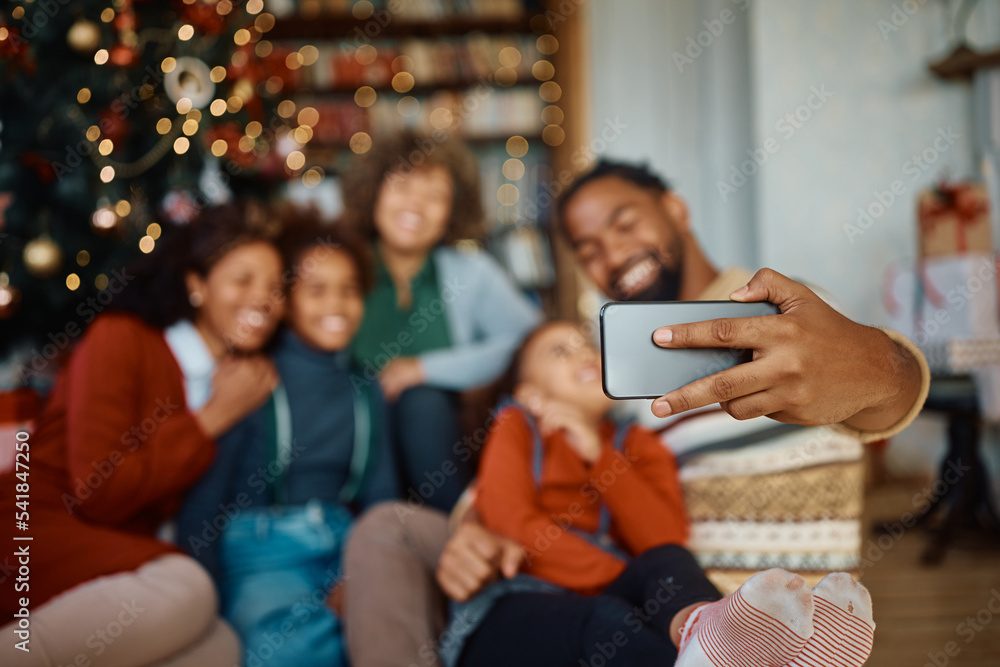 Obraz premium Close up of African American extended family taking selfie while celebrating Christmas at home.