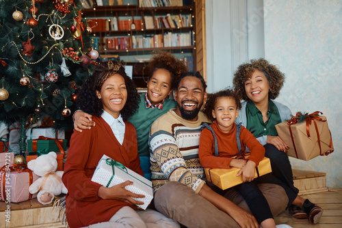 Portrait of happy black extended family with presents on Christmas day at home. photo