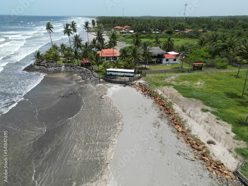 High angle of the Playa El Espino beach with calm waves and tropical trees on the sandy shore