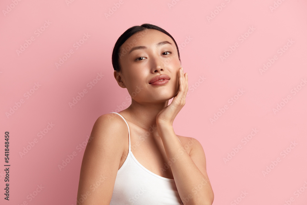 Tender Woman Touching Chick. Portrait of Positive Asian Woman Touching her Face and Smiling. Woman Appearance and Skin Care Concept Tender Woman Touching Chick. Portrait of Positive Asian Woman Touching her Face and Smiling. Woman Appearance and Skin Care Concept