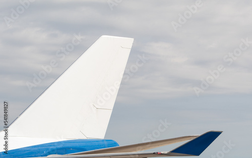 A white blank tail for a large blue jumbo-jet, airliner, seen on a cloudy day. 