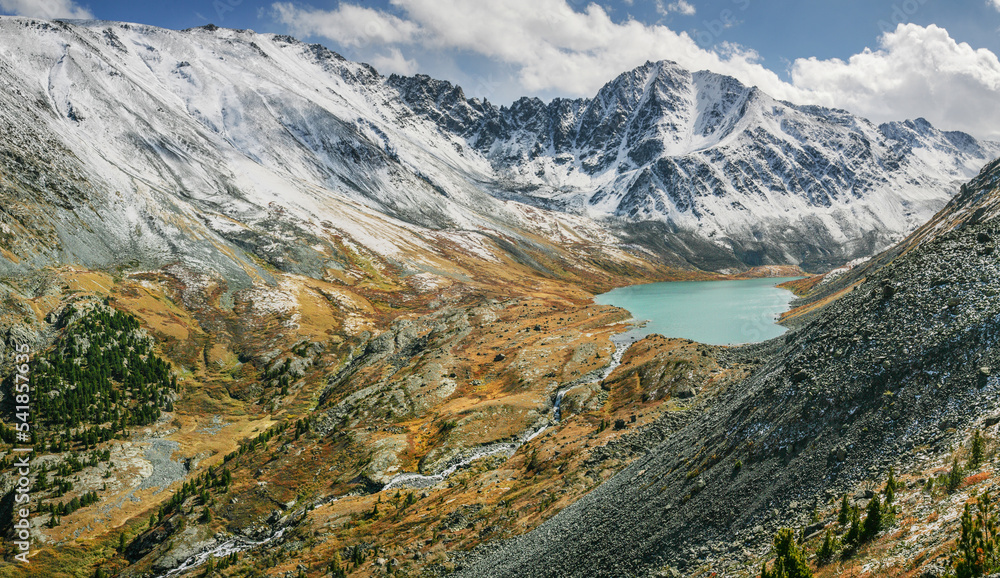 Mountain valley with a lake, snow-capped peaks, autumn view